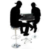 Silhouettes Of Two People Playing A Tabletop Arcade Machine On Stools