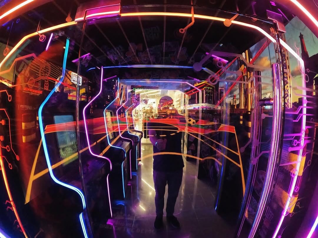 person stands in a vibrant arcade room