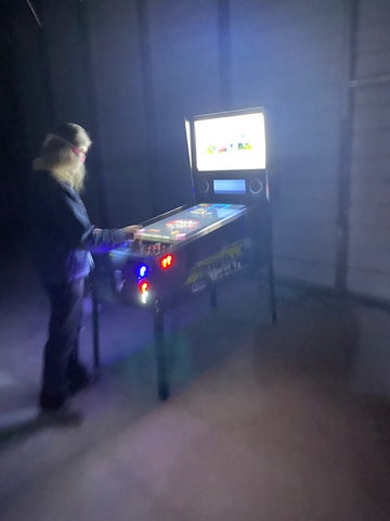 Person Playing With Pinball Arcade Machine