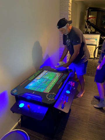 Man playing a cocktail arcade machine