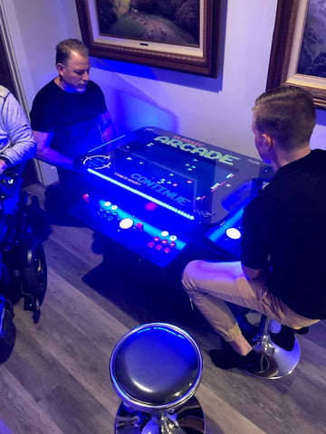 Two Men Playing A 'classic Arcade' Cocktail Table Machine